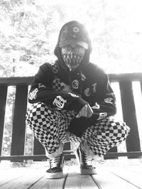 a black and white photo of a person wearing a checkered mask